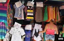 Detalle de un letrero que anuncia rebajas en una tienda de ropa importada ofertada por comerciantes privados.