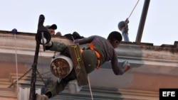 Dos hombres trabajan en la reparación de una vivienda.