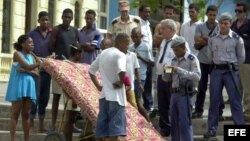 Policías cubanos detienen a un hombre que transporta un colchón, en la zona de La Habana Vieja.