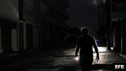 Un hombre camina con una linterna por el barrio de El Cerro, en La Habana, durante un apagón. EFE/Alejandro Ernesto